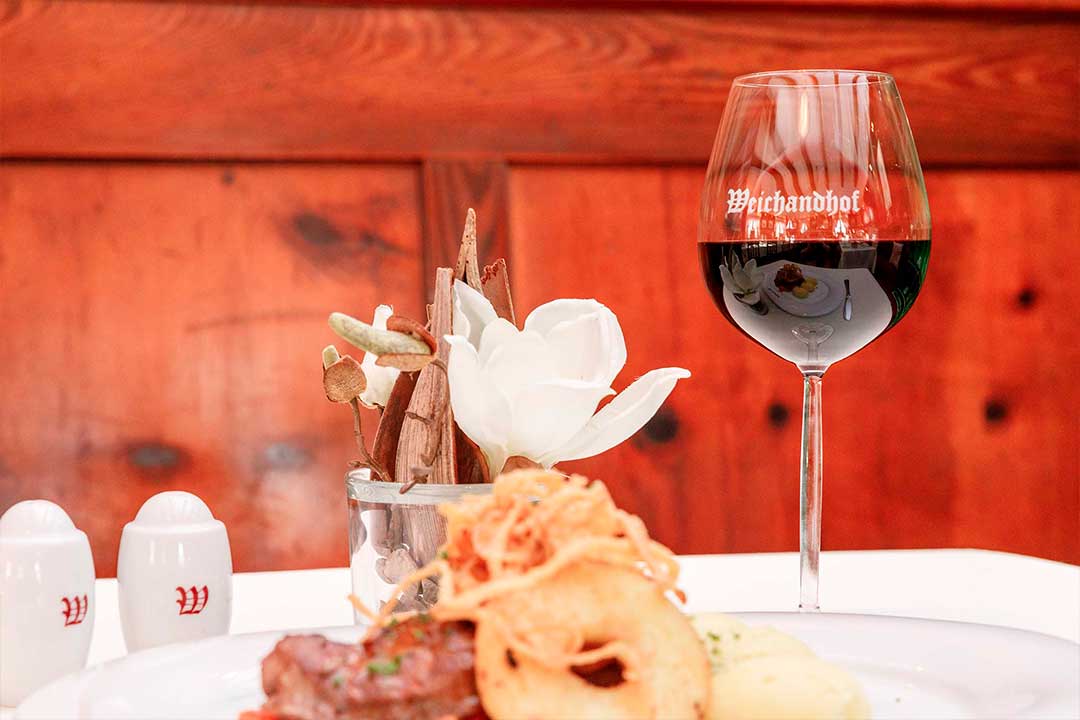 Close-Up Glas Rotwein mit winterlicher Tischdeko