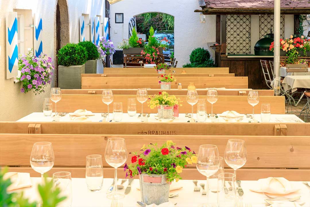 Gedeckter Tisch mit gefalteten Servietten und Gläsern im Biergarten
