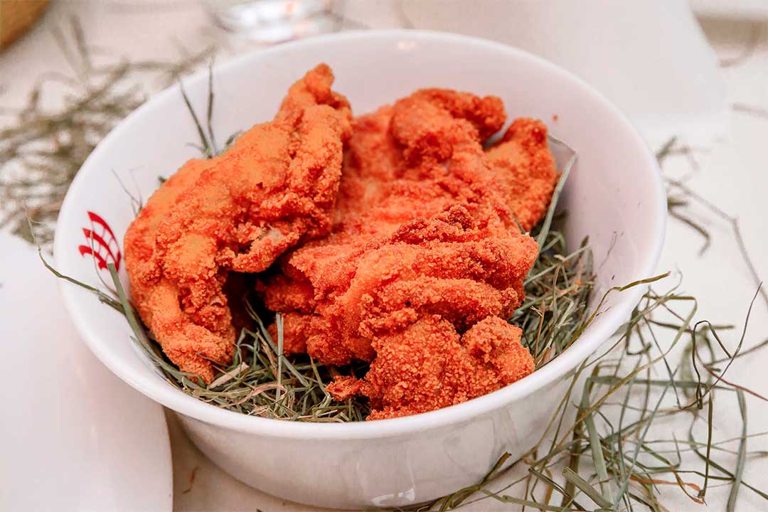 Ausgelöstes Wiener Backhuhn knusprig gebacken auf Heu